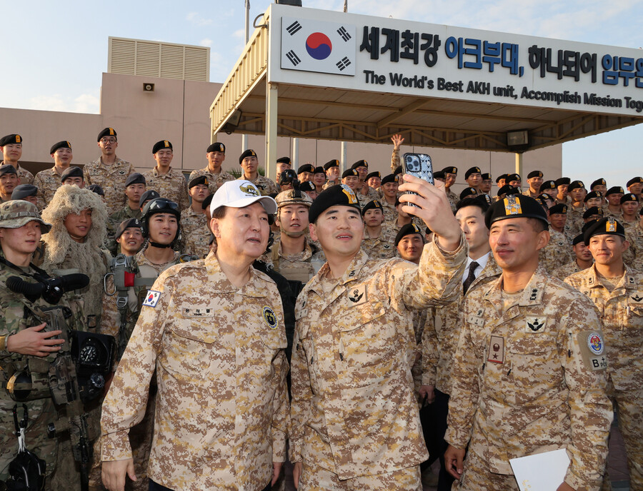 아랍에미리트(UAE)를 국빈 방문 중인 윤석열 대통령이 15일(현지시각) 현지에 파병중인 아크부대를 방문해, 명예 아크부대원 상징 모자를 쓰고 장병들과 사진을 찍고 있다. 연합뉴스