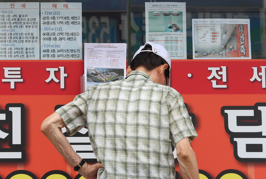 서울 서초구에 있는 한 부동산 앞에서 한 시민이 매물 목록, 재건축 안내문 등을 살펴보고 있다. 신소영 기자 viator@hani.co.kr