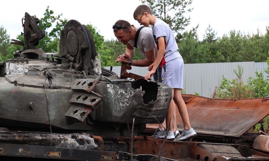 우크라이나 드미트리우카 지역 고속도로에 놓인 러시아군의 장갑차와 탱크 등을 부차에서 올하 소키르코의 남편과 아들이 살펴보고 있다. 드미트리우카/김혜윤 기자