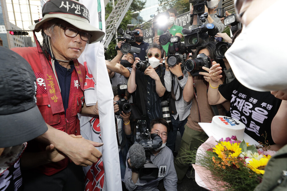 삼성항공에서 노조를 만들려다 해고돼 복직을 요구하며 서울 서초동 삼성사옥 앞 교통 폐회로텔레비전(CCTV) 철탑 위에서 355일 동안 고공노성을 이어 온 김용희씨가 29일 오후 삼성과 합의문을 작성한 뒤 농성을 접고 지상에 내려와 도와주신 분들의 환영을 받고 있다. 김명진 기자 littleprince@hani.co.kr