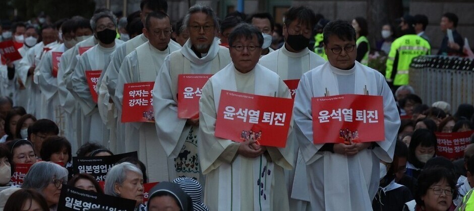 지난 10일 밤 서울광장에서 열린 ‘친일매국 검찰독재정권 퇴진과 주권회복을 위한 월요 시국미사’에서 사제들이 ‘윤석열 퇴진’이 적힌 글을 들고 행진하고 있다. 윤운식 선임기자