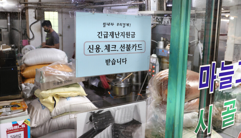 정부가 추석 전 코로나 상생국민지원금 지급을 결정한 26일 오전 서울 종로구 통인시장 점포에 긴급재난지원금 관련 안내문이 붙어 있다. 연합뉴스