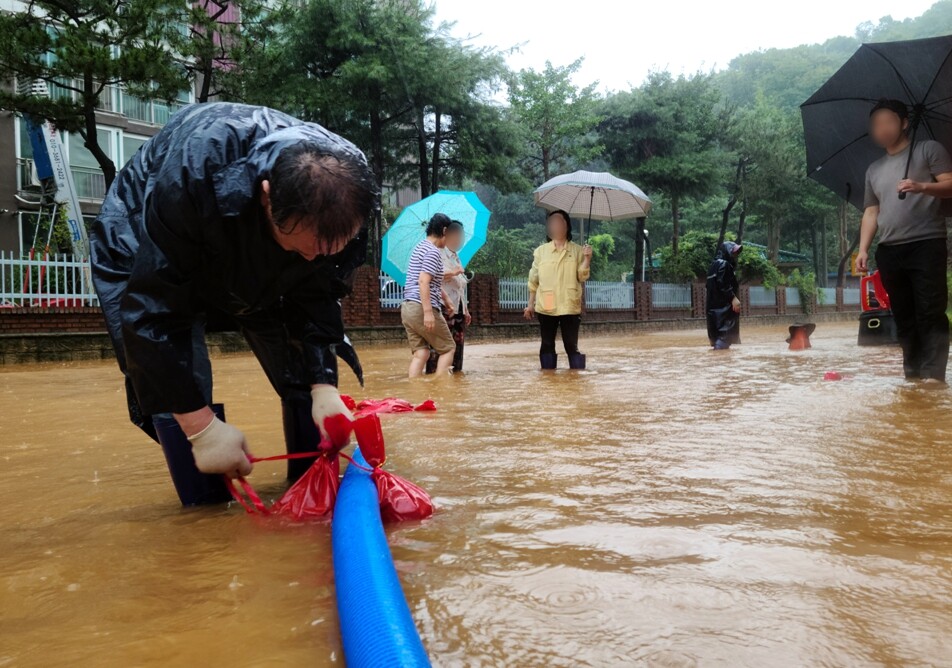 14일 전북 군산시 구암동 한 상가 건물 인근 도로가 이틀째 내린 집중호우로 침수돼 공무원과 주민들이 배수 작업을 하고 있다. 연합뉴스