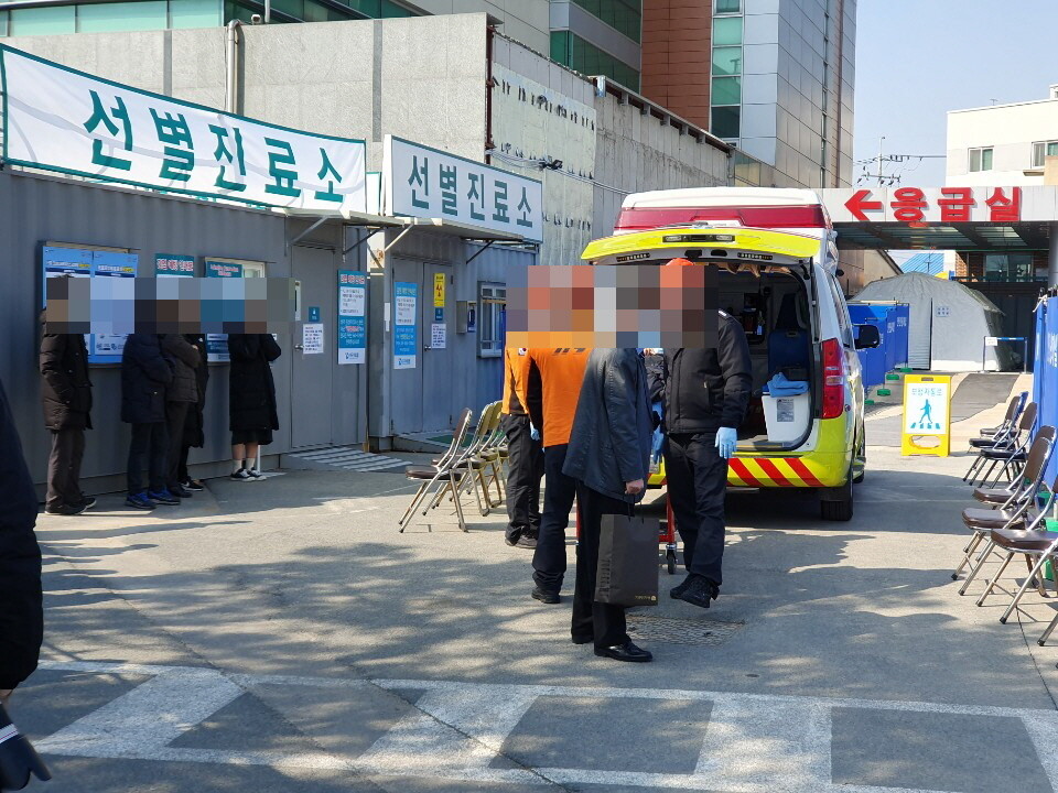 지난 20일 119구급대원이 대구의료원 선별진료소에 코로나19 의심 환자를 옮기고 있다.