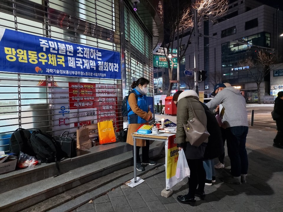 지난 2일 저녁 서울 마포구 망원동우체국 앞에서 주민들이 우체국 폐국 반대 서명운동에 참여하고 있다.