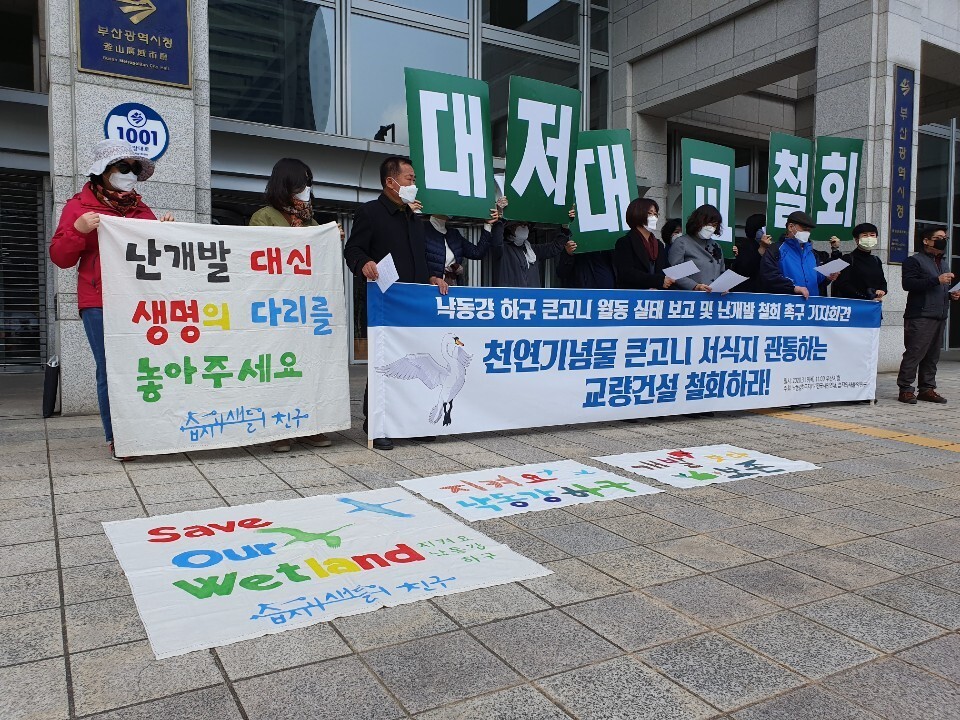 19일 부산시청 앞 광장에서 부산 환경단체들이 부산시에 낙동강을 잇는 다리 건설 추진 중단을 촉구하는 기자회견을 열었다.