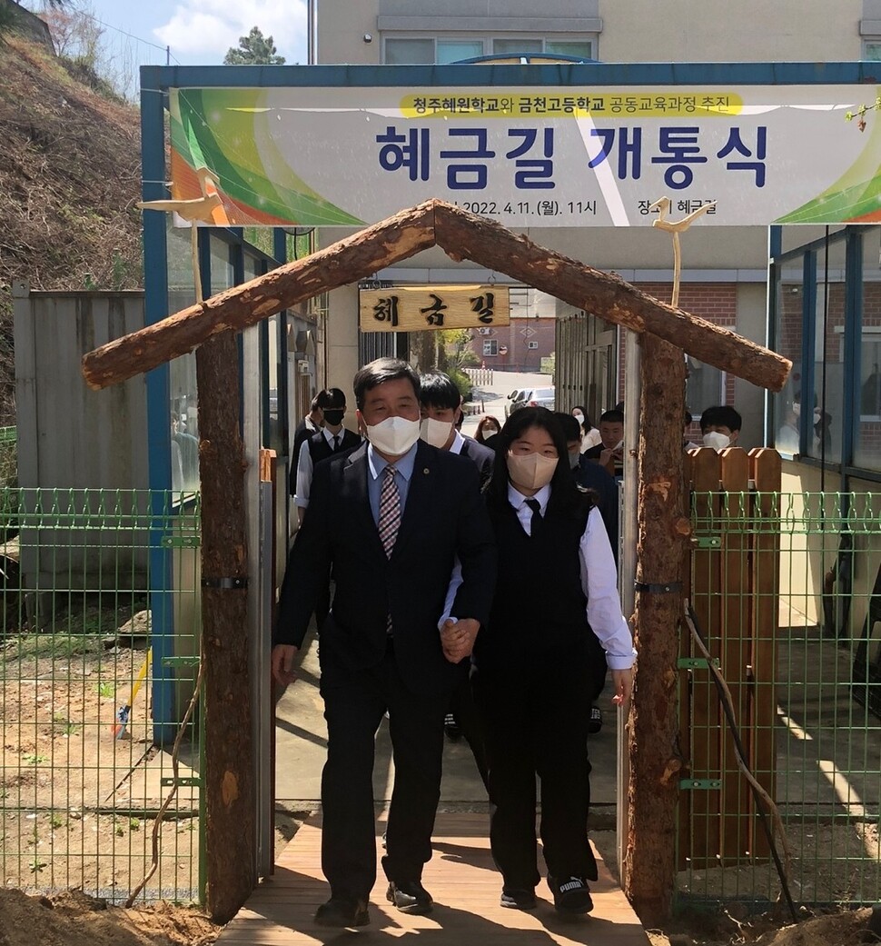 김명철 청주 금천고 교장과 한 학생이 11일 개통한 혜금길을 손을 잡고 지나고 있다.