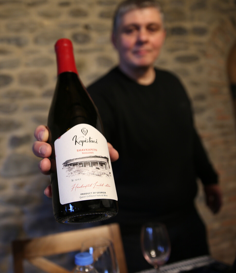 와인농장 카피스토니의 주인인 니코 초치슈빌리가 생산한 와인을 보여주고 있다.