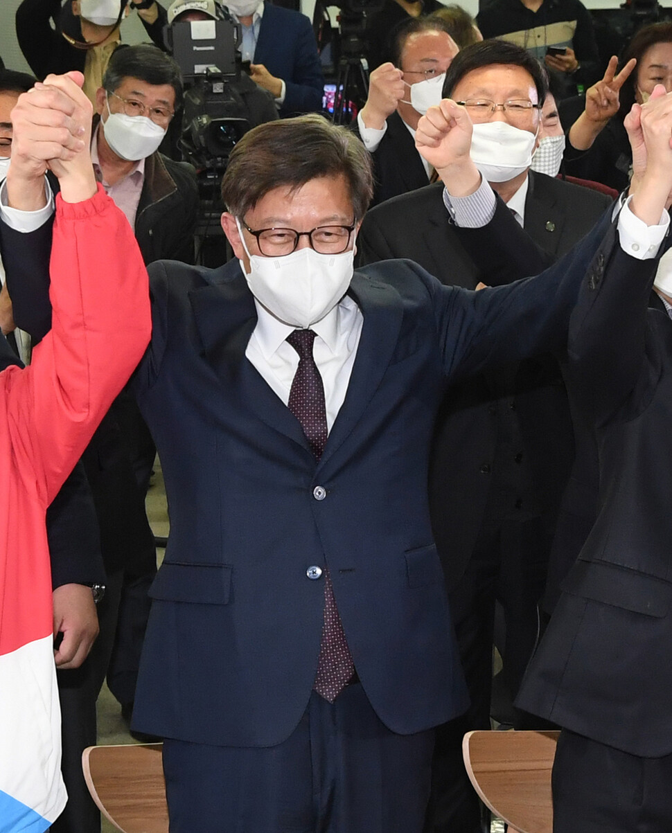 박형준 국민의힘 부산시장 후보가 7일 저녁 부산진구 선거사무소에서 출구조사 결과를 지켜본 뒤 의원들과 함께 손을 맞잡고 있다. 연합뉴스