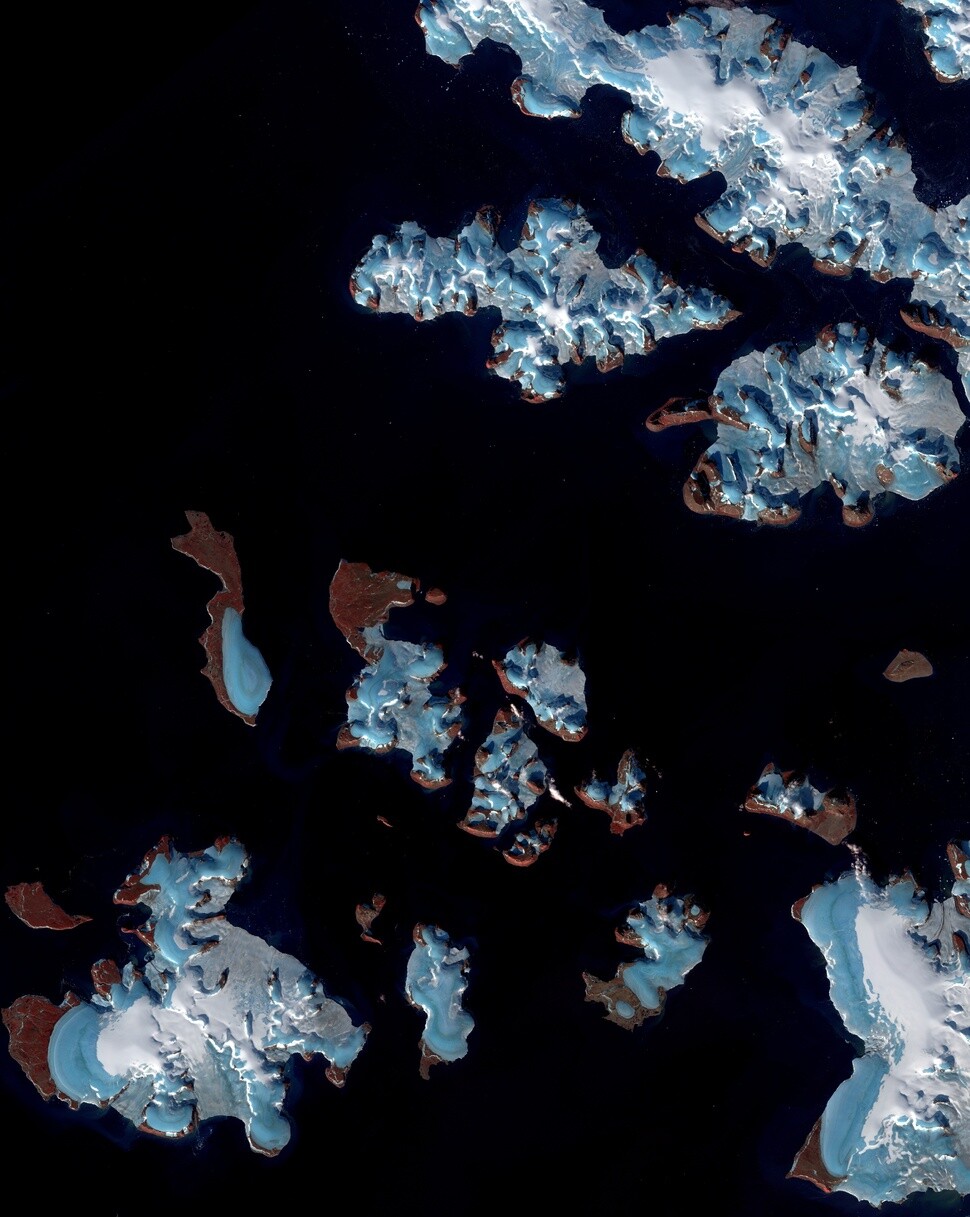 유럽연합의 측지 인공위성 센티널 2호가 2017년 9월12일에 촬영한 러시아 극지 프란츠 조세프 군도(고동색)의 빙하(파란색). 빙하들은 눈(하얀색)으로 덮여 있기도 하지만 일부는 눈이 거의 덮여 있지 않거나 전혀 없어 빙하가 녹아 내렸음을 보여준다. ‘네이처’ 제공