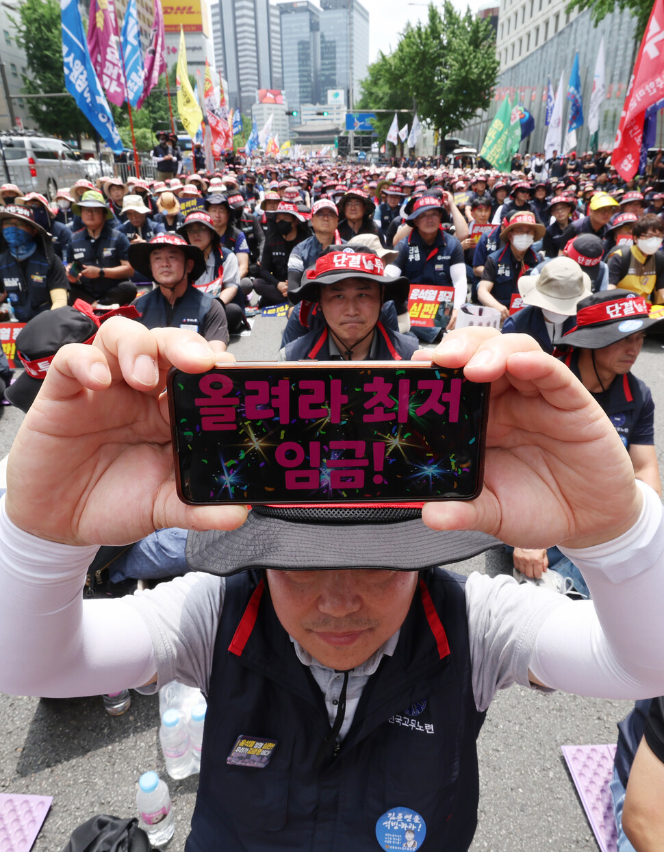 참석자들이 ‘올려라 최저임금!’이라는 문구가 적힌 스마트폰을 들어보이고 있다. 신소영 기자