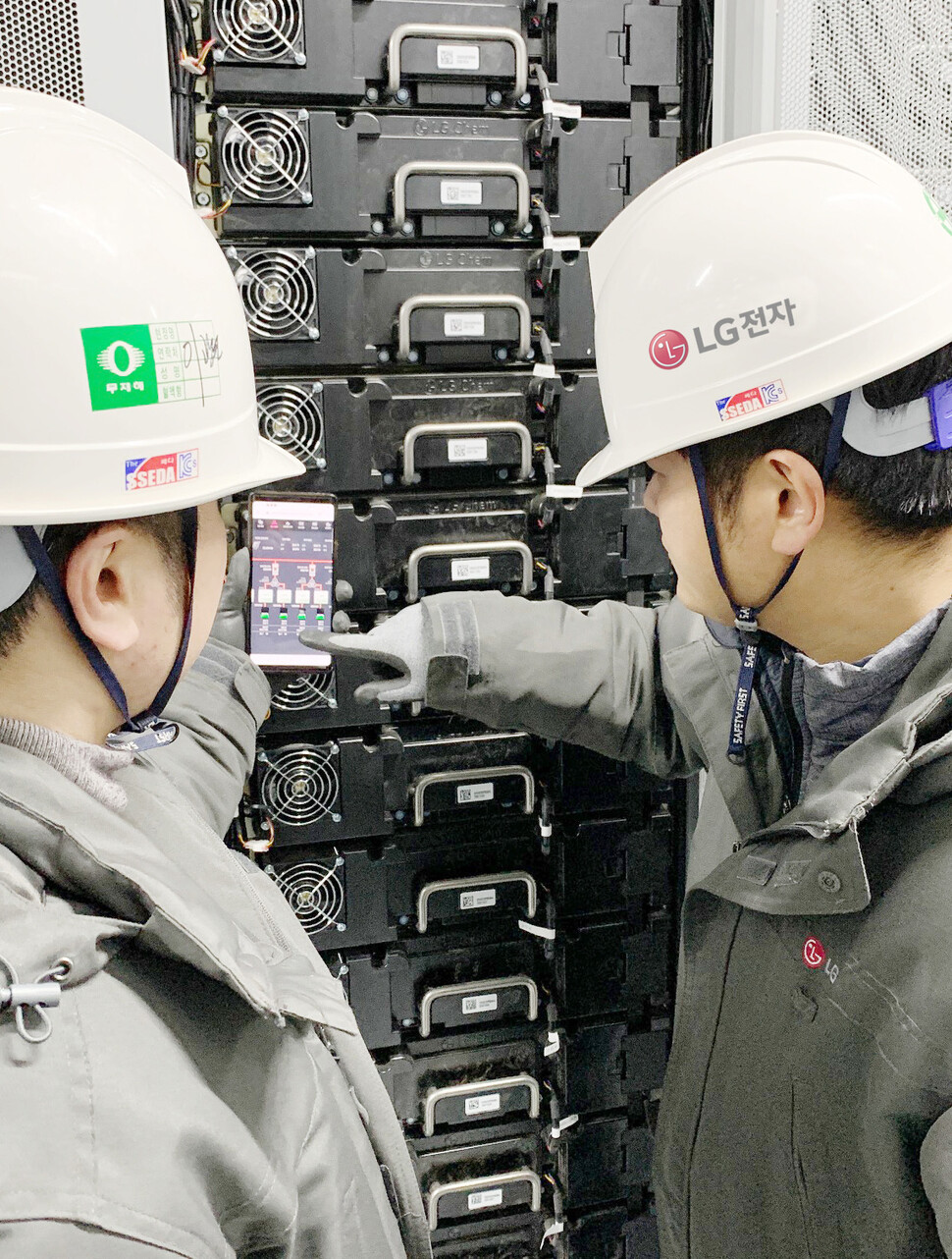 LG전자 직원들이 전남 신안군 안좌스마트팜앤쏠라시티에 구축한 에너지저장장치(ESS; Energy Storage System)의 동작상황을 스마트폰을 통해 확인하고 있다.