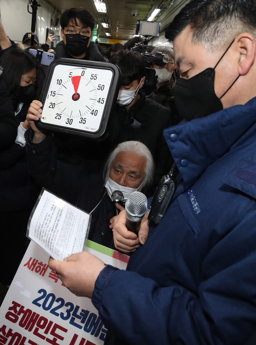 서울중앙지방법원은 서울교통공사가 전장연에 제기한 민사소송에 대해 5분 이내 지하철 탑승하도록 조정안을 내놓았으나 서울교통공사는 수용하지 않았다. 박경석 대표가 지하철 탑승을 원하며 5분 표시가 되어 있는 시계를 경고방송을 하는 삼각지역장을 향해 들어 보이고 있다. 신소영 기자 viator@hani.co.kr