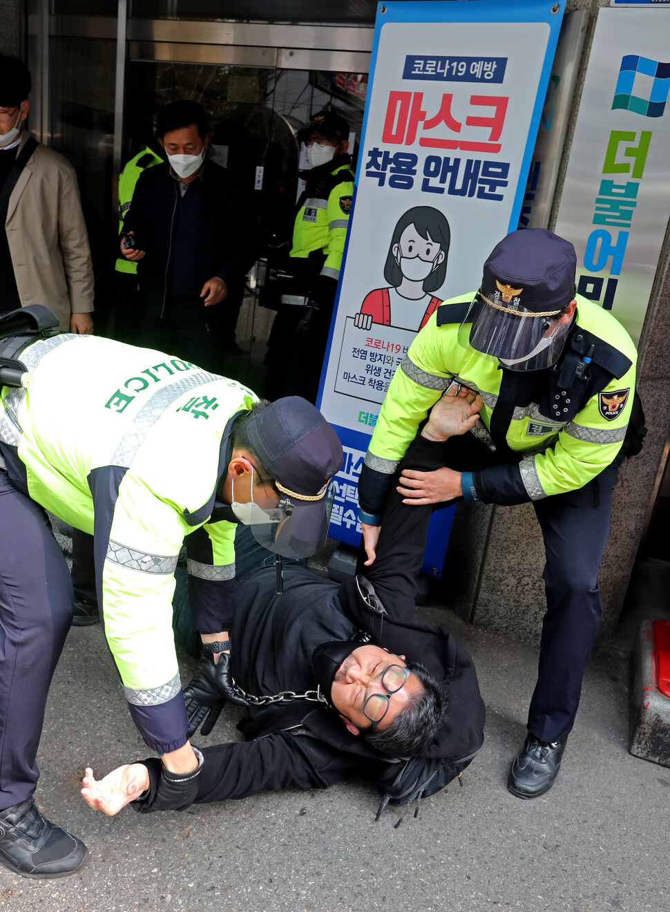 멸종저항서울 회원들이 15일 오전 서울 여의도 더불어민주당사입구에서 가덕도신공항 추진하는 민주당을 규탄하며 기습시위를 벌이다 경찰에게 제지를 받고 있다. 이정용 선임기자 lee312@hani.co.kr