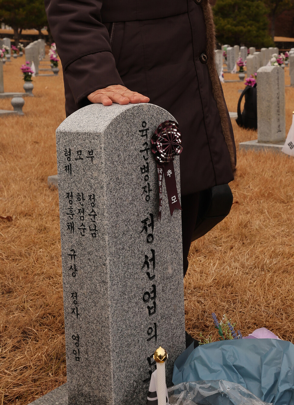 12·12 군사반란 당시 전두환 신군부 반란군과 전투하다 전사한 정선엽 병장의 누나인 정정자씨 12일 오전 서울 동작구 국립서울현충원에서 고 정선엽 병장 묘역 참배를 마친 후 묘비를 쓰다듬고 있다. 신소영 기자