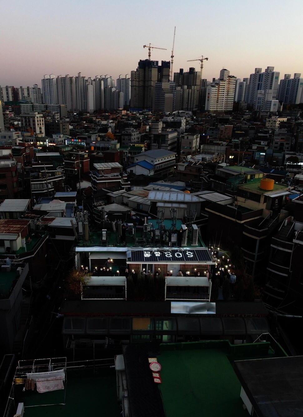 ‘비정규노동자쉼터 꿀잠’ 상근활동가, 효성첨단소재 해고노동자, 인권활동가 등이 서울 영등포 신길동 꿀잠 옥상에서 휴대폰 불빛을 밝히고 있다. 박종식 기자 anaki@hani.co.kr