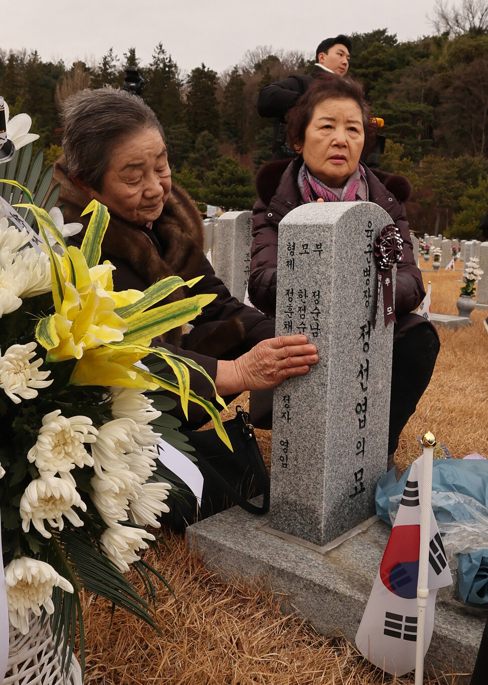 12·12 군사반란 당시 전두환 신군부 반란군과 전투하다 전사한 정선엽 병장의 누나인 정정자(왼쪽)씨와 정영임씨가 12일 오전 서울 동작구 국립서울현충원에서 고 정선엽 병장 묘역 참배를 마친 후 묘비를 바라보고 있다. 신소영 기자