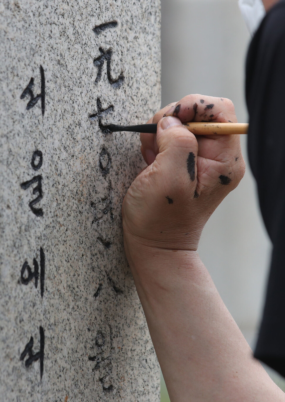 현충일을 하루 앞둔 5일 오전 서울 동작구 국립서울현충원 고 염영만 중사의 묘소에서 염 중상의 아들이 바래진 묘비 글자에 색을 칠하고 있다. 백소아 기자