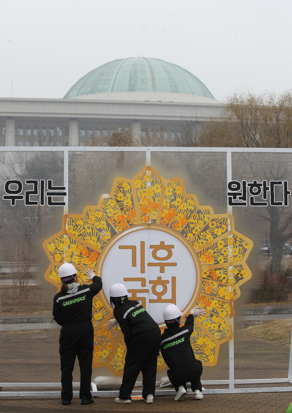 9일 오전 서울 국회의사당 둔치 주차장 인근에서 그린피스 그린뉴딜 시민행동 3기 회원들이 국회 기후위기 대응 촉구하는 ‘기후국회’ 배지 손도장 행위극을 진행하고 있다. 참가자들이 국회 배지 모양 조형물에 손도장을 찍고 있다. 신소영 기자