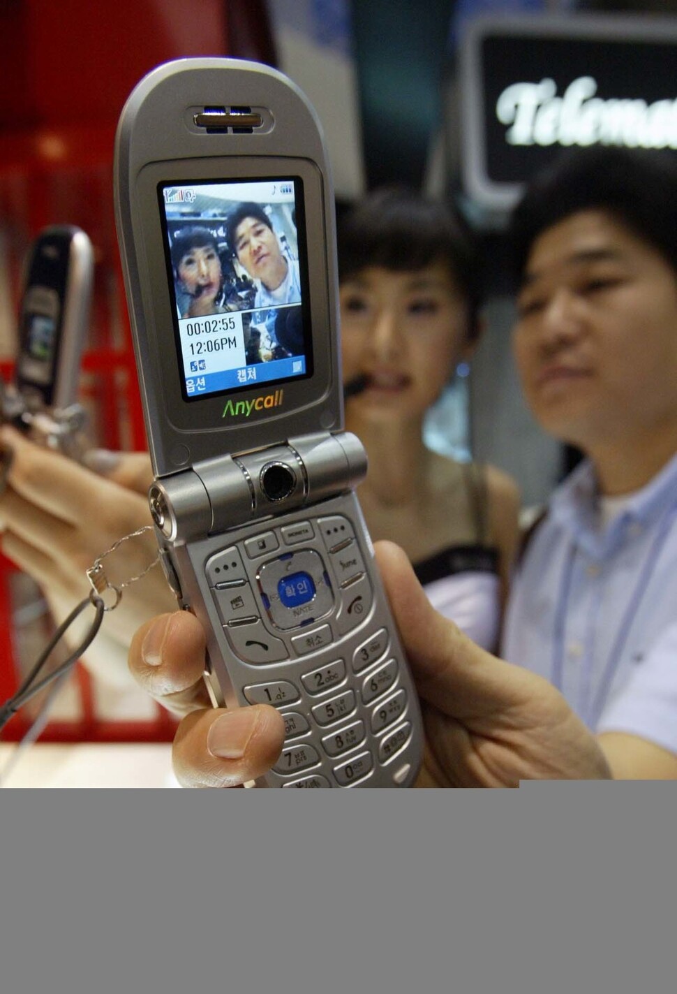 2005년 열린 국제 정보통신 및 이동통신 전시회에서 애니콜 전화기를 이용해 3G 화상통화를 시연하는 모습. 휴대폰에 달린 카메라는 원래 화상통신을 위해 장착된 부품이기에, 3G 핵심 서비스가 되리라 다들 생각했지만, 한국에선 널리 쓰이지 못했다. 2020년이 되기 전에는. 이종근 기자 촬영.