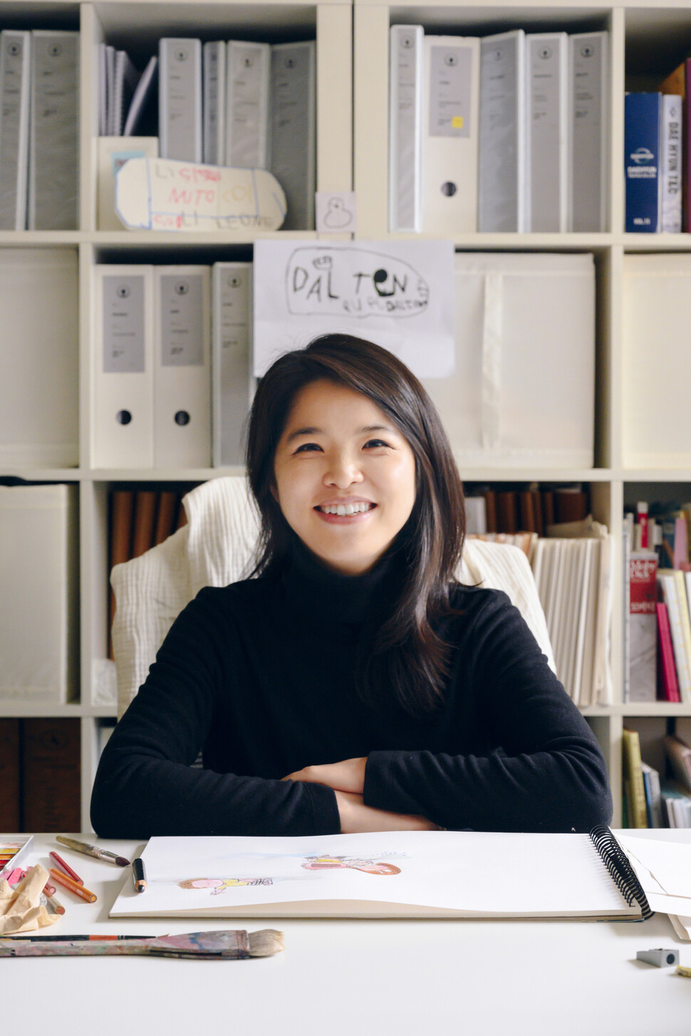 노인경 작가가 남편과 함께 운영하는 디자인 회사 사무실에서 인터뷰 질문에 답하고 있다. 뒤로 아들 아루(6)가 쓴 손글씨가 보인다. 해란 작가