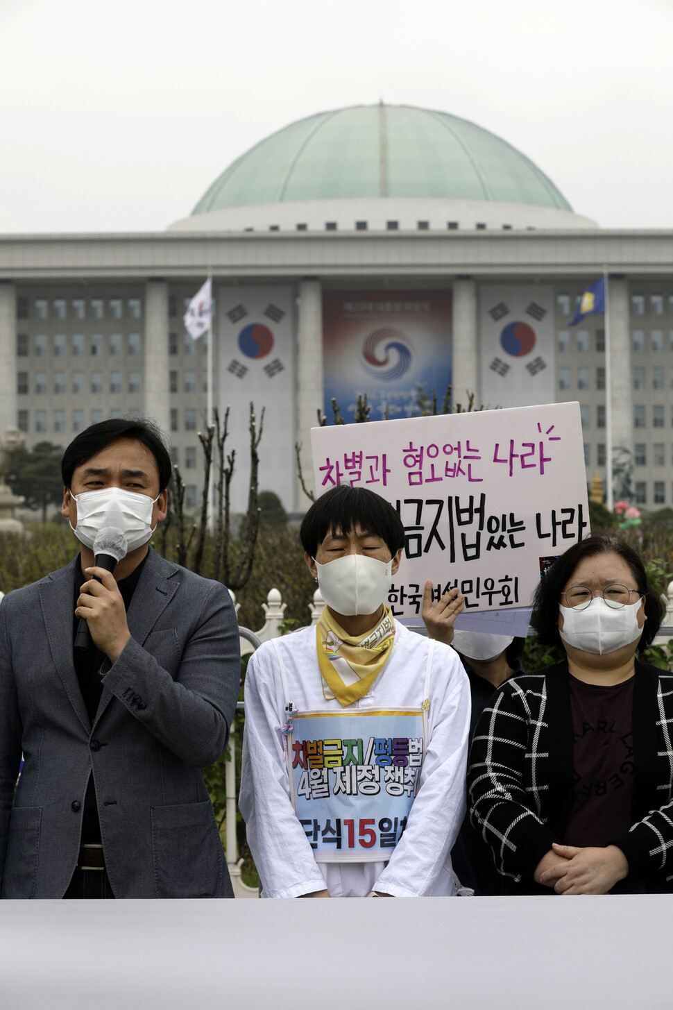 언론개혁시민연대와 전국언론노동조합, 한국기자협회, 한국여성민우회 등 언론·미디어단체들이 25일 오전 국회 앞에서 4월 임시국회에서 차별금지법 제정을 촉구하고 있다. 차별금지법 제정을 촉구하며 15일째 단식농성 중인 인권운동 사랑방 미류 활동가(가운데)가 눈을 감고 있다. 김명진 기자