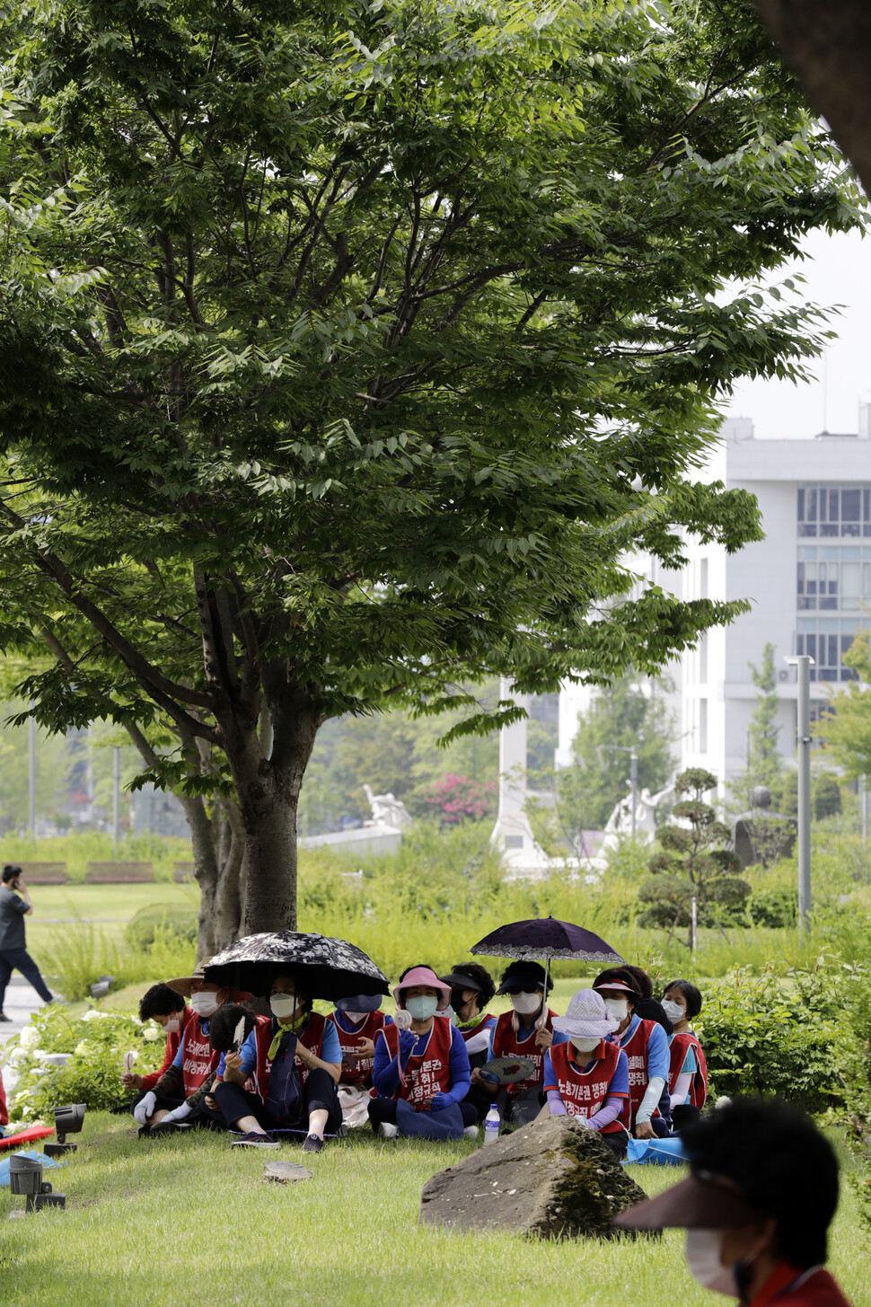 연세대학교 청소노동자들이 나무그늘 아래에 앉아 있다. 김명진 기자