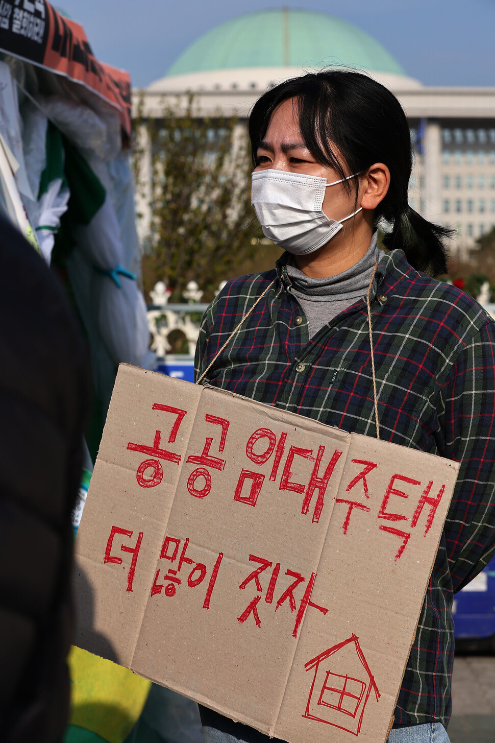 ‘내놔라 공공임대’농성단’이 거대 양당의 공공임대 예산 삭감과 관련해 7일 오전 국회 앞에서 연 기자회견에서 한 참석자가 손팻말을 목에 걸고 있다. 김혜윤 기자