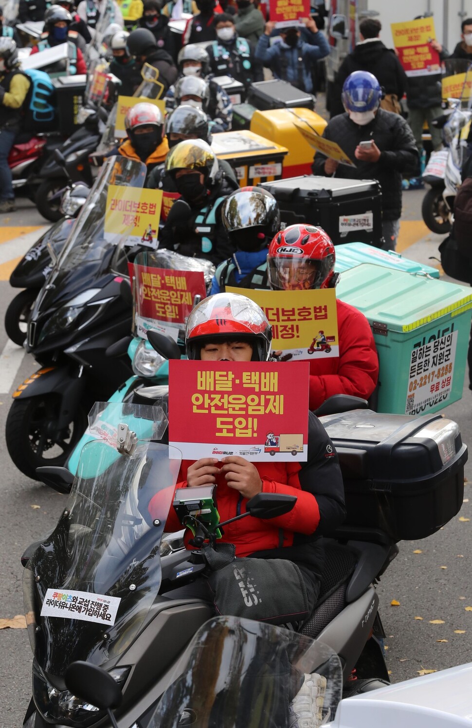 참가자들이 라이더보호법 제정과 배달·택배안전운임제 도입을 촉구하는 내용이 적힌 손팻말을 들고 있다. 신소영 기자