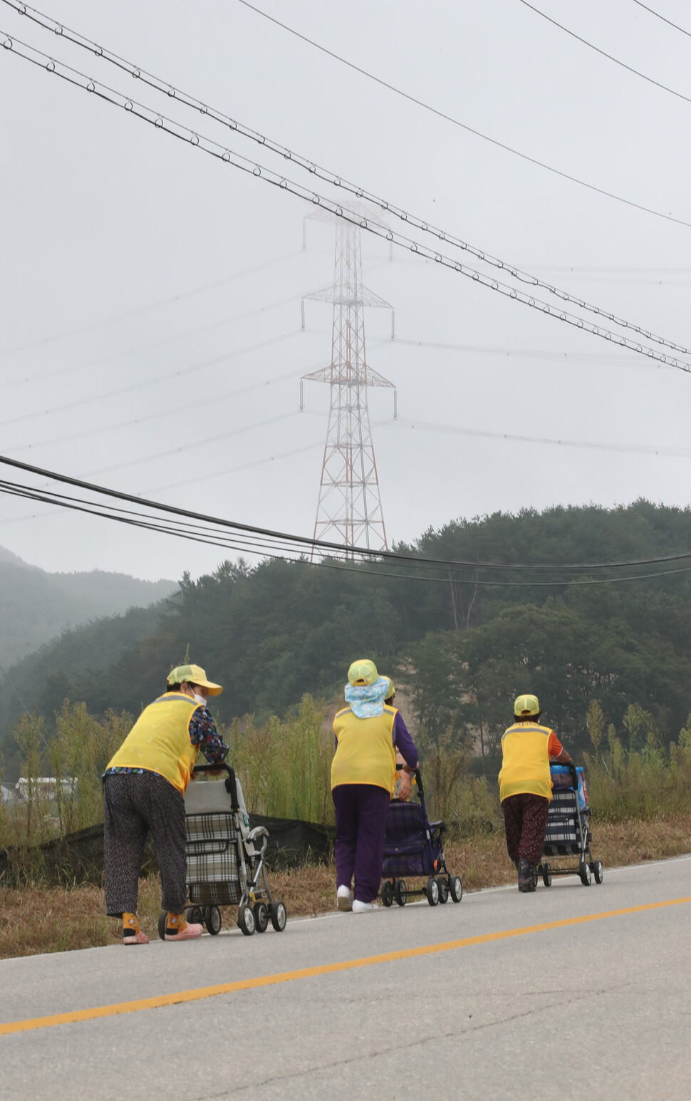 삼은마을 주민들이 송전탑 앞을 지나고 있다. 홍천/박종식 기자