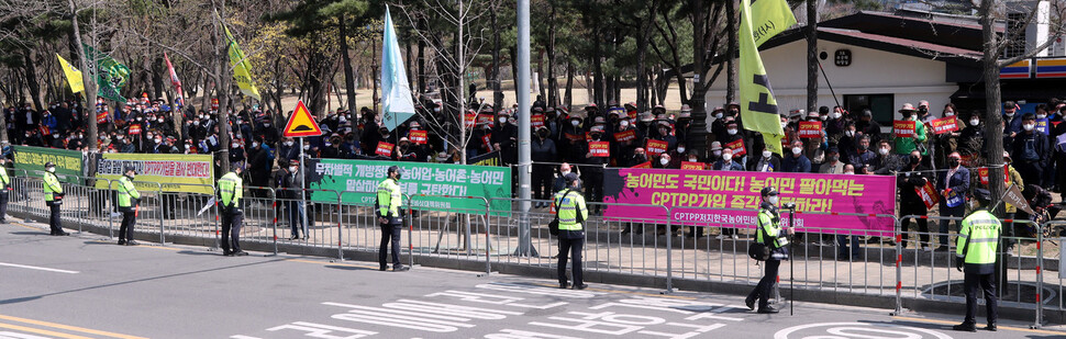 4일 오후 서울 여의도 산업은행 본점 앞에서 열린 포괄적·점진적 환태평양경제동반자협정(CPTPP) 가입 저지를 위한 농어민 총궐기대회 본행사장에 참석하지 못한 농민들이 주변에서 행사를 지켜보고 있다. 김경호 선임기자