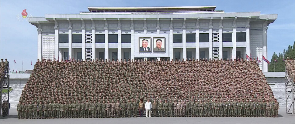 김정은 북한 국무위원장이 지난 18일 비상방역전에서 임무를 완수하고 위훈을 세운 군의부문(의무부대) 전투원들을 만나 축하 연설하고 격려하며 기념사진을 찍었다고 조선중앙티브이가 지난 19일 보도했다. 김 위원장을 비롯해 기념사진을 찍고 있는 전투원들 모두 마스크를 쓰지 않고 있다. 조선중앙티브이 화면 갈무리 연합뉴스