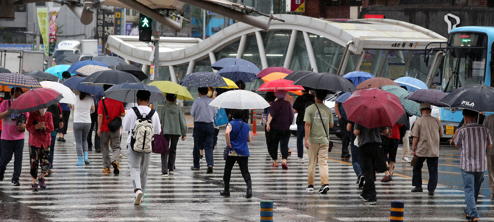 부산에 호우주의보가 내려진 지난 18일 오전 부산도시철도 동래역 인근에서 시민들이 우산을 쓰고 발걸음을 재촉하고 있다. 연합뉴스