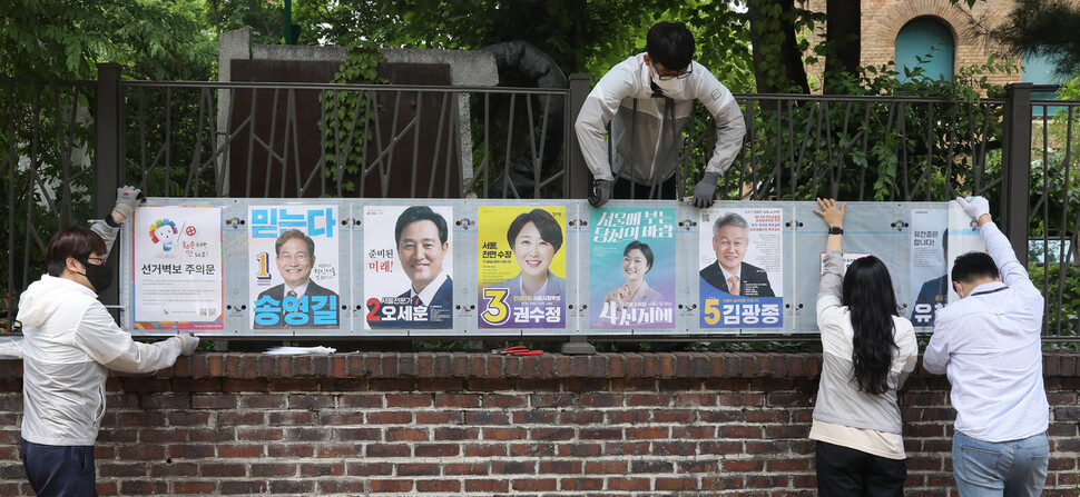 6.1지방선거 공식 선거운동 시작일인 19일 오후 종로구 선관위 직원들이 서울 종로구 동숭동에서 이번 선거에 출마한 서울시장과 구청장, 시의원, 교육감 후보들을 소개하는 선거벽보를 붙이고 있다. 윤운식 선임기자 yws@hani.co.kr