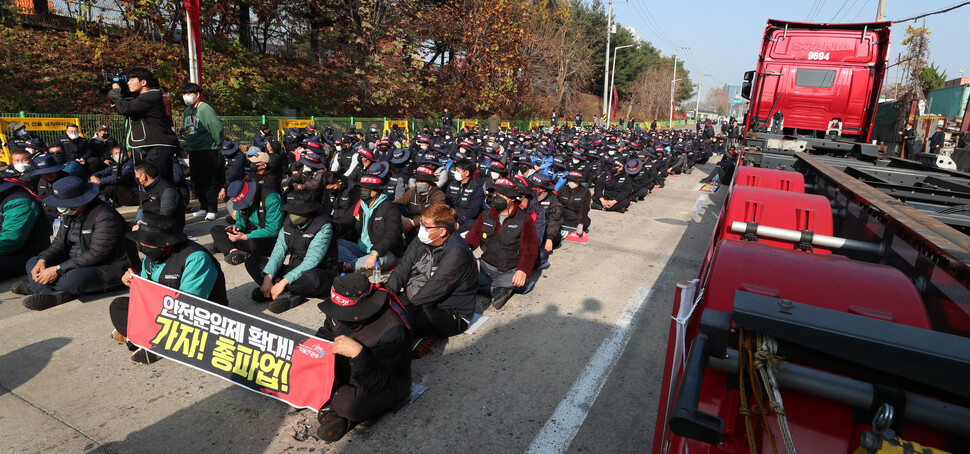 민주노총 공공운수노조 화물연대가 총파업을 시작한 24일 오전 경기 의왕 내륙컨테이너기지(ICD) 제1터미널 앞에서 열린 화물연대 서울경기지역본부 총파업 출정식에 참석한 조합원들이 안전운임제 확대 등의 구호를 외치고 있다. 김정효 기자 hyopd@hani.co.kr