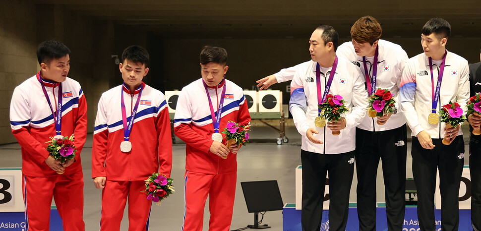 9월25일 중국 항저우 푸양 인후 스포츠센터에서 열린 2022 항저우아시안게임 남자 사격 10m 러닝타깃 단체전에서 금메달을 획득한 한국의 정유진과 선수들이 북한 선수들에게 함께 기념 촬영을 할 것을 요청했지만 은메달을 획득한 북한 선수들이 이에 응하지 않고 있다. 항저우/연합뉴스