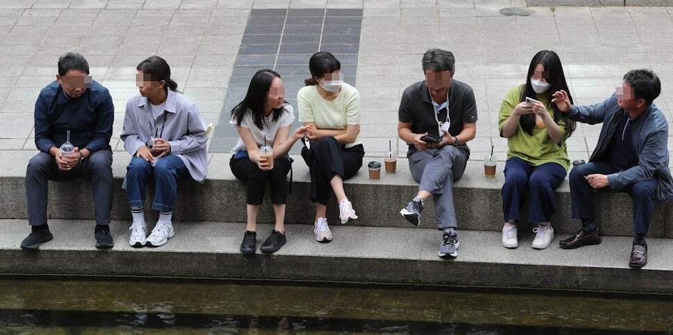 야외에서 마스크 착용이 모임 인원과 장소 상관없이 모두 ‘자율’로 바뀐 26일 마스크를 벗은 직장인들이 서울 청계천에 앉아 이야기를 나누고 있다. 김정효 기자 hyopd@hani.co.kr