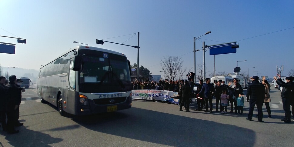 충북 진천 주민 등이 15일 국가공무원 인재개발원에서 격리 생활을 마치고 버스를 타고 퇴소하는 중국 우한 교민들에게 손을 흔들며 환송하고 있다.