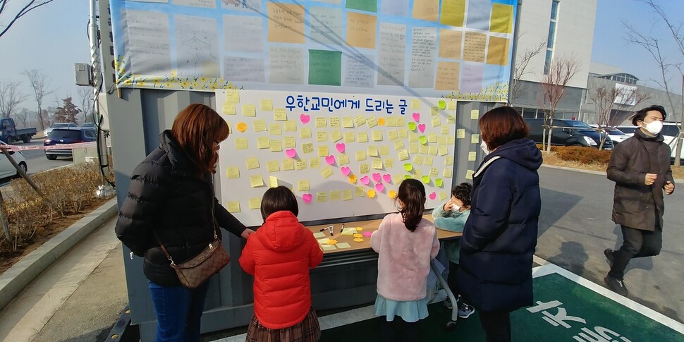 지진천 주민 등이 15일 중국 우한 교민 퇴소를 축하는 붙임쪽지 글을 쓰고 있다.
