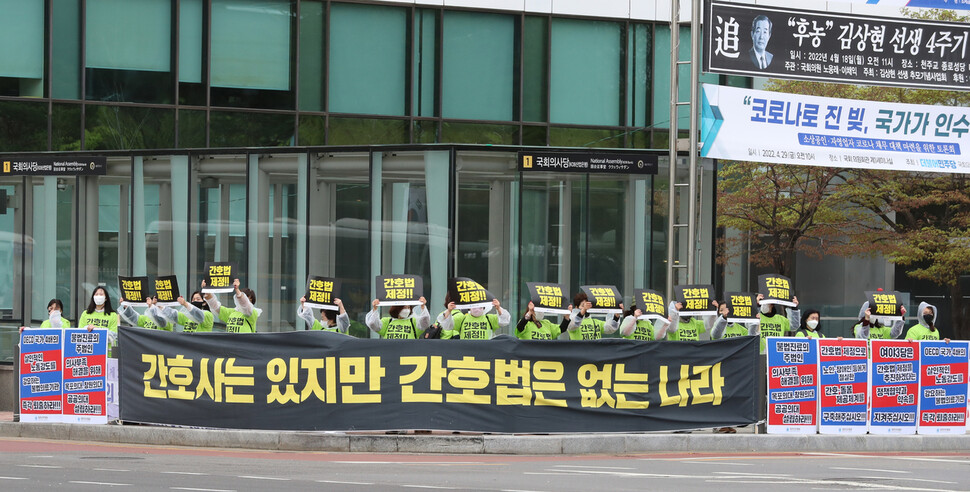 대한간호협회가 서울 여의도 국회 앞에서 ‘간호법 제정과 불법진료,불법의료 기관 퇴출을 위한 수요집회’를 연 13일 오전 국회 길 건너편에서 집회에 함께 하는 회원들이 손팻말을 들어보이고 있다. 신소영 기자