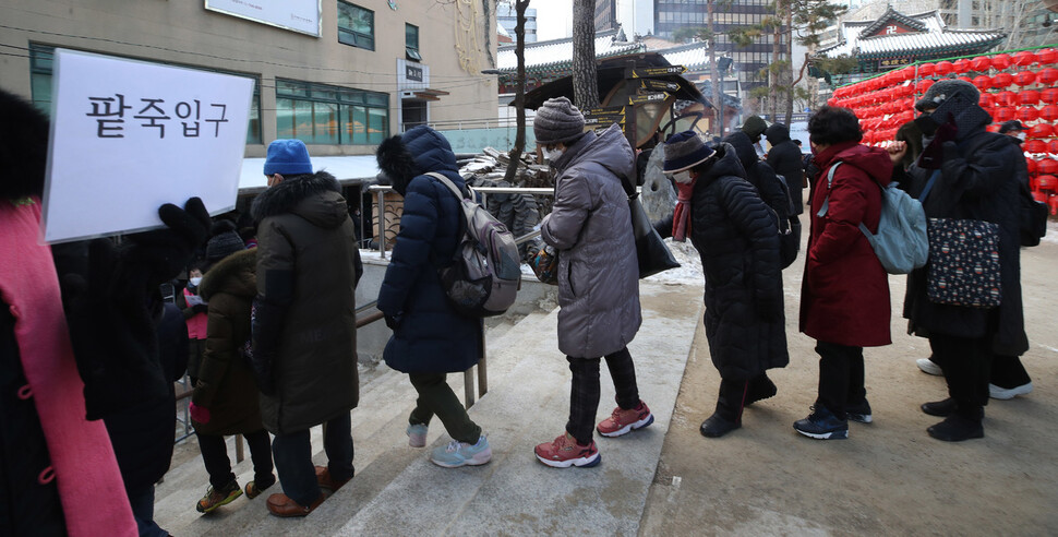 절기상 동지인 22일 오전 서울 종로구 조계사 만발 공양간에서 자원봉사자들이 신도들에게 8000인분의 팥죽을 만들어 신도들이 팥죽을 먹기위해 줄을 서고 있다. 신소영 기자 viator@hani.co.kr