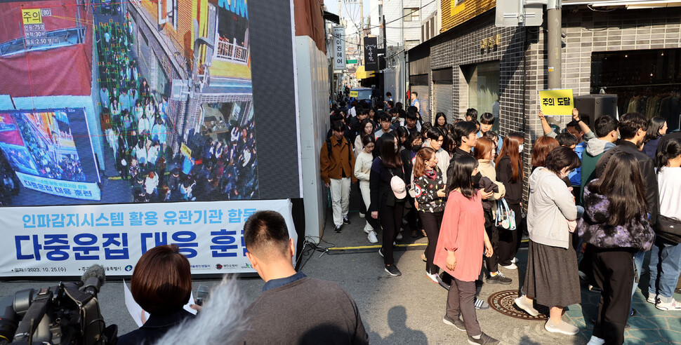 25일 오후 서울 건대 맛의거리 입구 인근에서 열린 인파감지시스템 가동 점검 및 훈련에서 참석자들이 주의 단계 훈련을 하고 있다. 김경호 선임기자