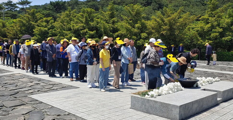 추모객들이 노무현 전 대통령 묘역에 국화를 헌화하고 있다. 최상원 기자