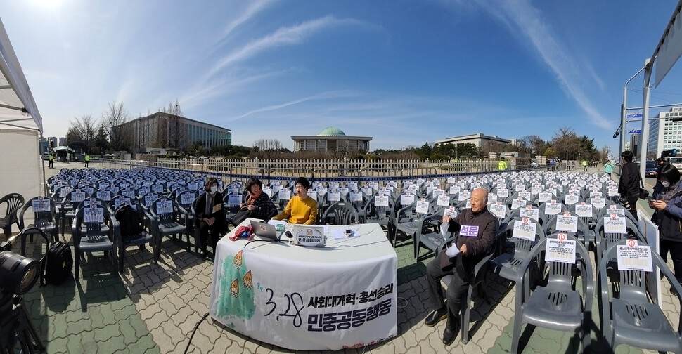 민중공동행동이 28일 오후 국회 앞에서 빈 의자 300개(국회의원 숫자)를 놓은 채 3·28 온라인 민중정치대회를 진행하고 있다. 당초 민중공동행동은 사회개혁을 촉구하는 대규모 집회를 열 예정이었으나 코로나19 확산을 막기 위해 전국 동시다발 실천, 온라인 1만 공동행동 등 변화된 방식으로 ‘사회대개혁 총선 승리를 위한 3.28 공동행동'을 진행했다. 백소아 기자 thanks@hani.co.kr