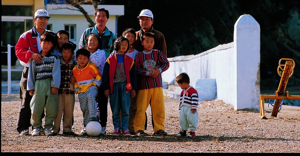 1997년 3월 인천 남부초등학교 이작분교 전교생 8명이 학교 운동장에서 교직원과 함께 찍은 사진. 맨 오른쪽은 형을 따라 등교한 김민욱(당시 4살)씨. 김씨는 사진 속 학생들이 모두 떠난 대이작도에 홀로 남아 섬을 지키고 있다.