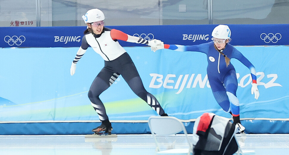 박지우(왼쪽)가 19일 중국 베이징 국립 스피드스케이팅 경기장(오벌)에서 열린 2022 베이징겨울올림픽 스피드스케이팅 여자 매스스타트 준결승에서 함께 넘어진 러시아올림픽위원회(ROC) 선수의 팔을 잡아 일으켜 준 뒤 함께 달리고 있다. 베이징/연합뉴스