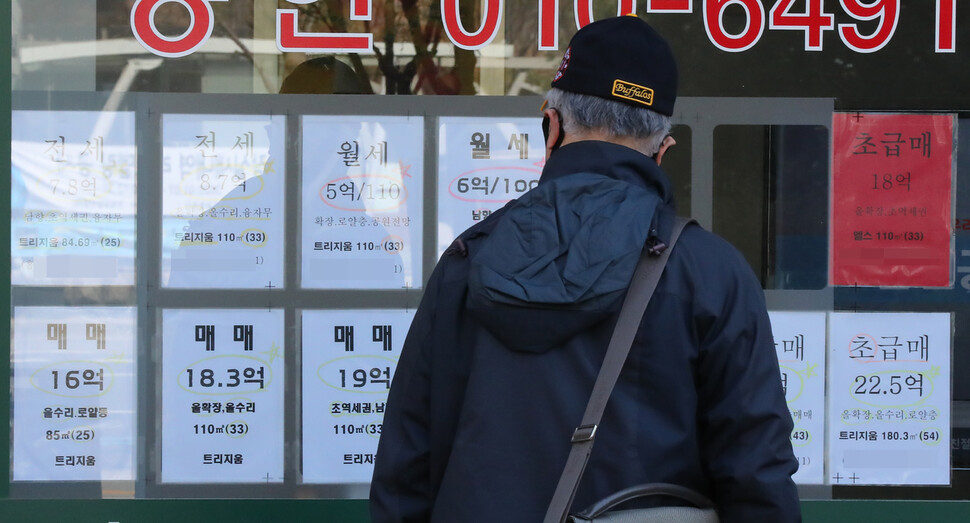 서울의 부동산중개소 앞에 한 시민이 부동산 광고를 보고 있다. 연합뉴스