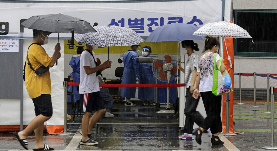 장대비 속에서 코로나19 검사를 받기 위해 시민들이 선별진료소로 향하고 있다. 김명진 기자