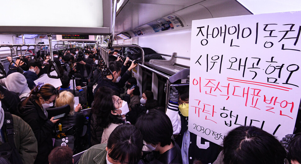 전국장애인차별철폐연대(전장연)와 시민단체가 28일 서울 종로구 경복궁역 3호선에서 25차 ‘출근길 지하철 탑니다'를 위해 지하철에 탑승해 손팻말을 들고 있다. 공동취재사진