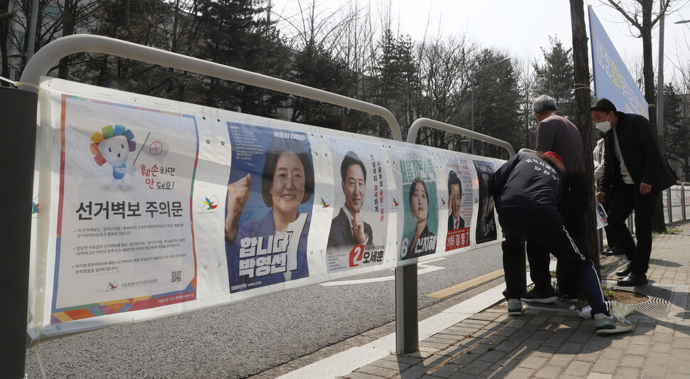 4·7 재보궐 선거 공식 선거운동 첫날인 25일 낮 서울 양천구 신정7동주민센터 직원들이 목동 12단지 인근 골목에 선거 벽보를 걸고 있다. 김혜윤 기자